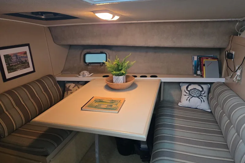 Slide: The Image of 1986 Silverton 34 Convertible Flybridge interior with striped seating, table, and decor. - 25