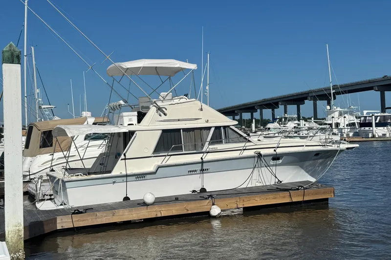 Slide: The Image of 1986 Silverton 34 Convertible Flybridge docked at marina under clear blue sky. - 3