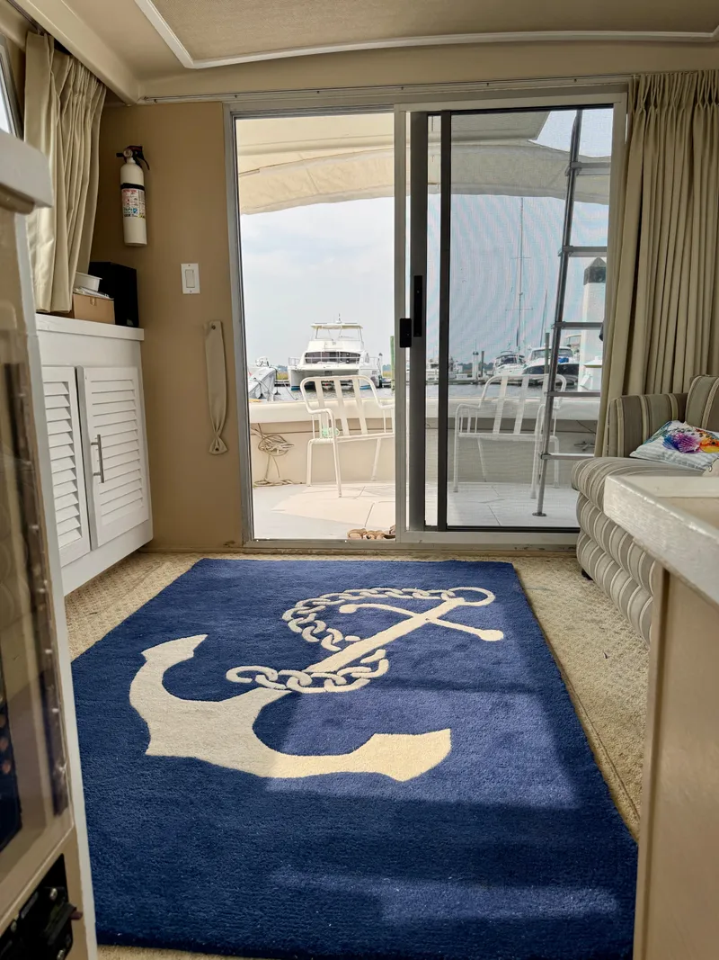 Slide: The Image of Interior of 1986 Silverton 34 Convertible Flybridge with nautical-themed rug and marina view. - 30