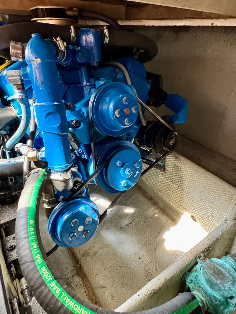 Slide: The Image of 1986 Silverton 34 Convertible Flybridge engine, featuring blue components and belts. - 35