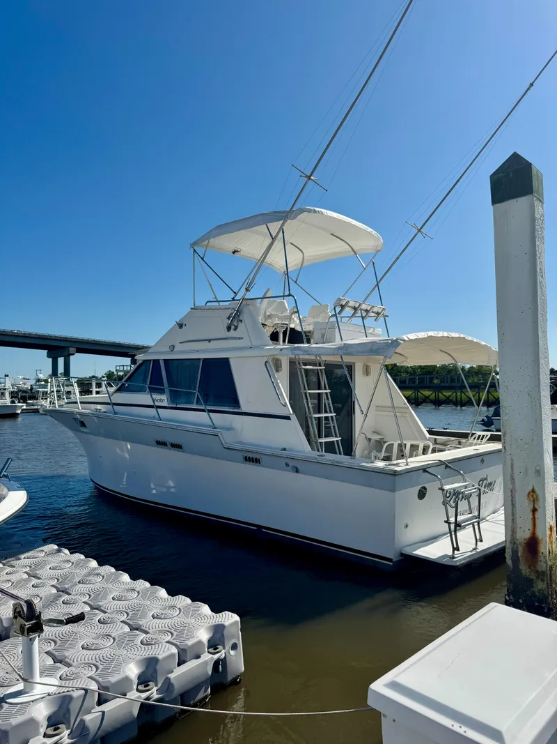 Slide: The Image of 1986 Silverton 34 Convertible Flybridge docked at marina under clear blue sky. - 4