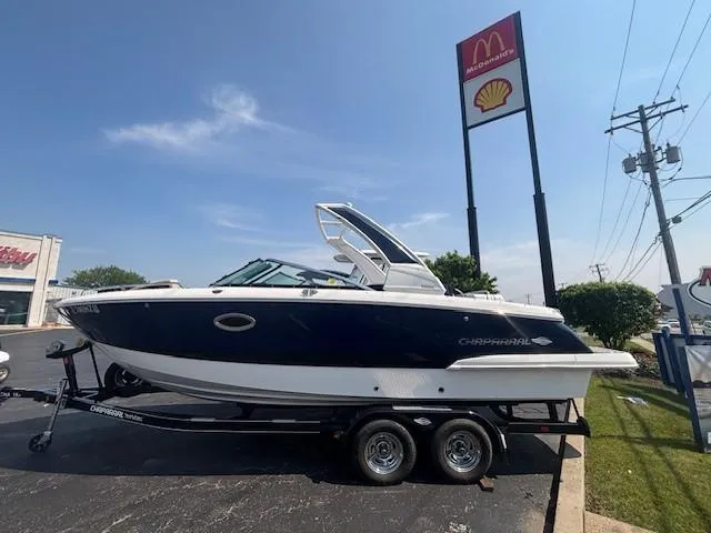 The Image of 2020 Chaparral 257 SSX boat on trailer, blue and white design, parked outdoors. - 0