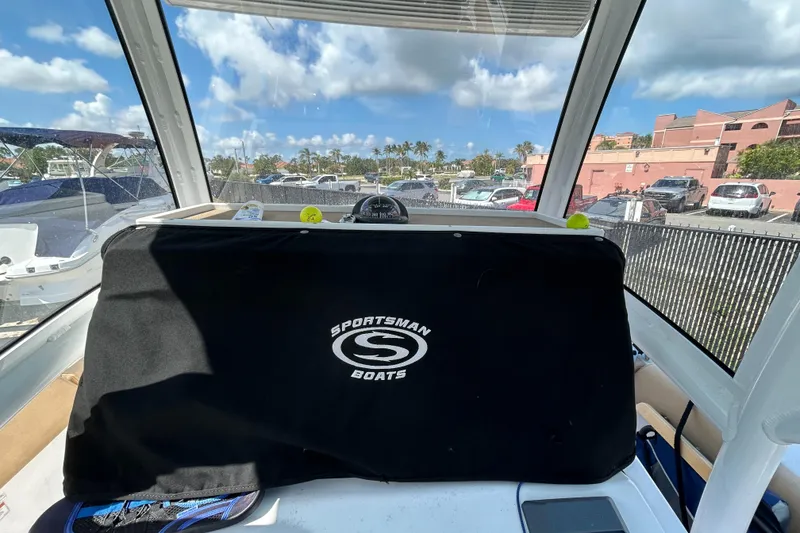 Slide: The Image of 2018 Sportsman 282 boat interior with cover, parked near waterfront buildings. - 15