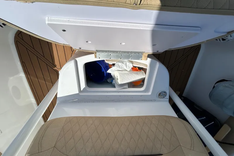 Slide: The Image of 2018 Sportsman 282 boat storage compartment with open lid and visible contents. - 17