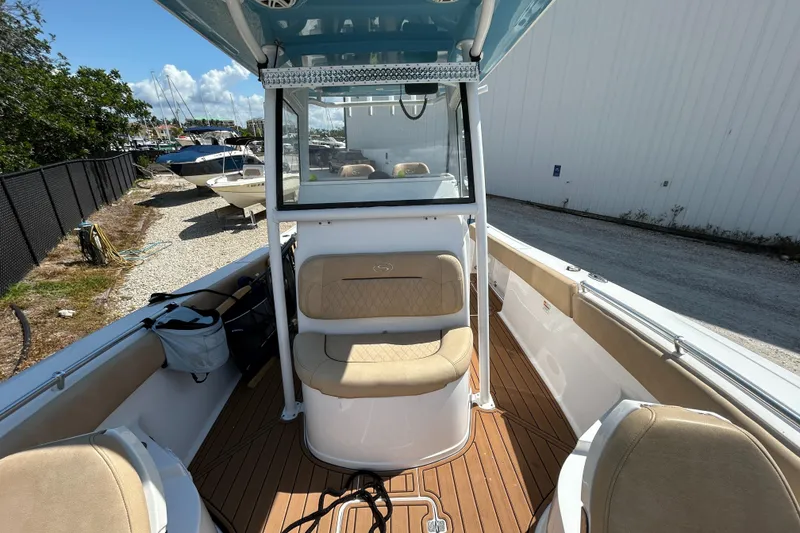 Slide: The Image of 2018 Sportsman 282 boat interior with seating and console, docked outdoors. - 19