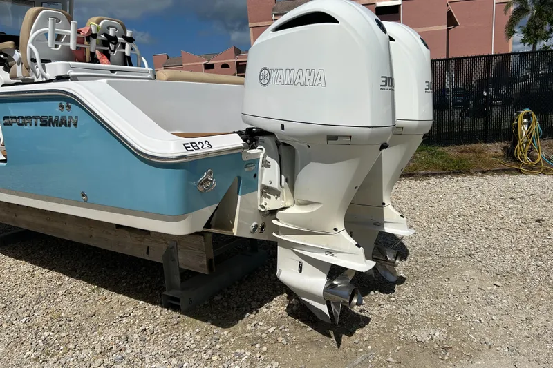 Slide: The Image of 2018 Sportsman 282 boat with dual Yamaha outboard engines on gravel surface. - 2