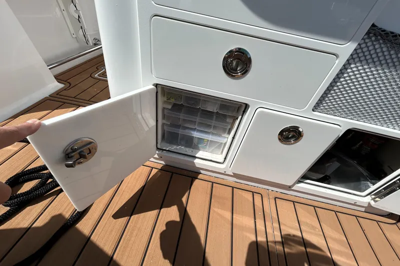Slide: The Image of Storage compartments on a 2018 Sportsman 282 boat with teak flooring. - 25