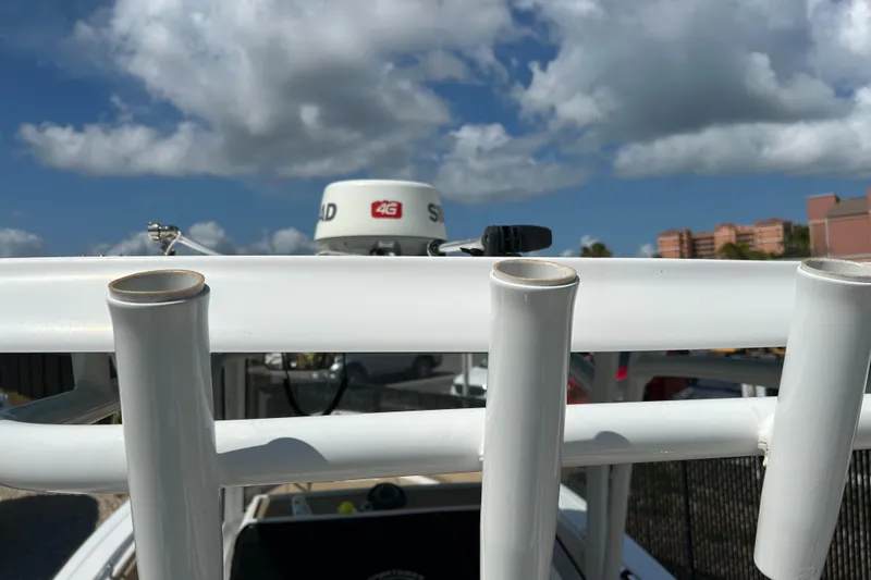 Slide: The Image of 2018 Sportsman 282 boat with rod holders and radar, under a partly cloudy sky. - 6