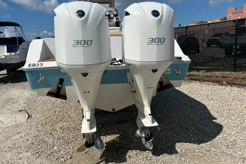 Slide: The Image of Twin 300 horsepower outboard engines on a 2018 Sportsman 282 boat, parked on gravel. - 8