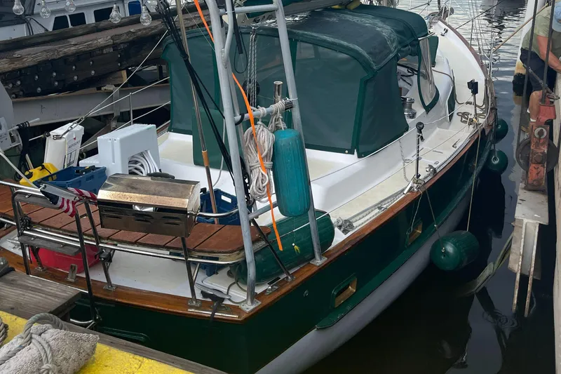 Slide: The Image of 1986 Irwin 43 Mk II Cruiser docked, featuring green canopy and deck equipment. - 20