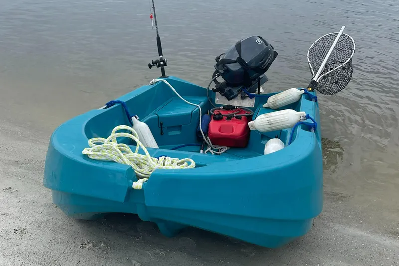Slide: The Image of Small blue fishing boat with motor, rope, and net on sandy shore. - 25