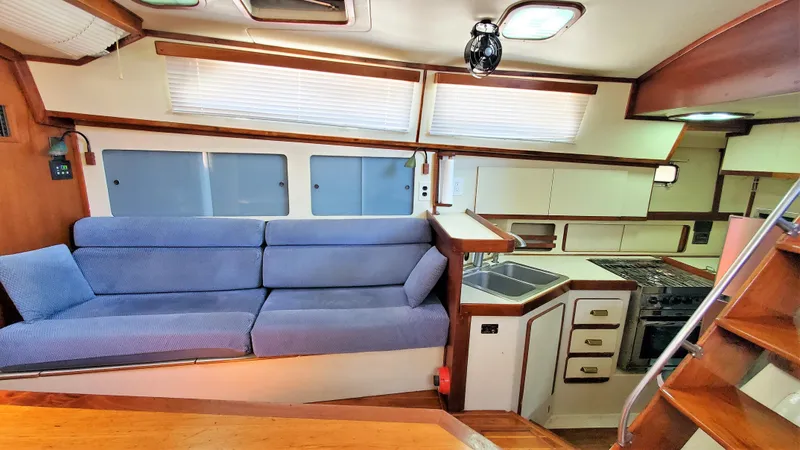 Slide: The Image of Interior of 1986 Irwin 43 Mk II Cruiser with blue sofa and compact kitchen. - 4