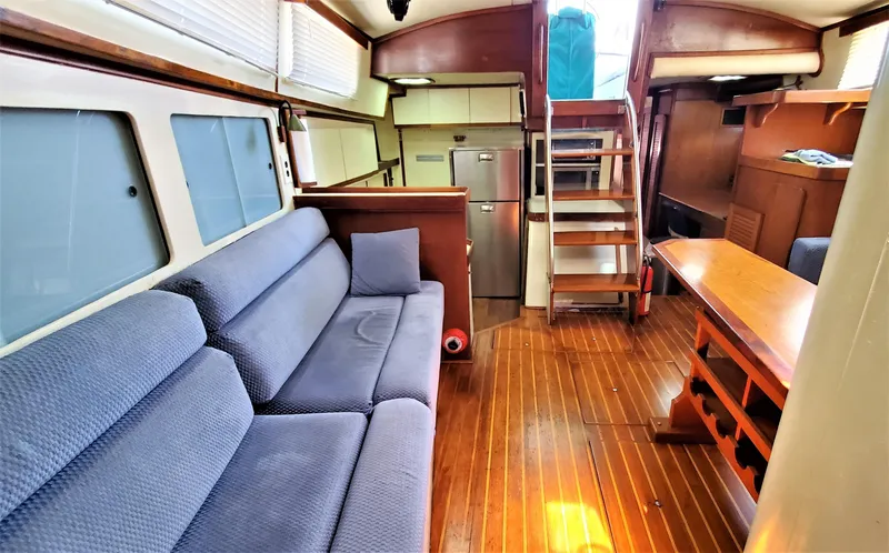 Slide: The Image of Interior of 1986 Irwin 43 Mk II Cruiser with blue sofa and wooden flooring. - 5