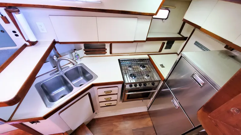 Slide: The Image of 1986 Irwin 43 Mk II Cruiser kitchen with dual sink, stove, and stainless steel fridge. - 7