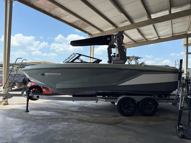 Slide: The Image of 2022 Nautique Super Air G23 boat on trailer under shelter, side view. - 1