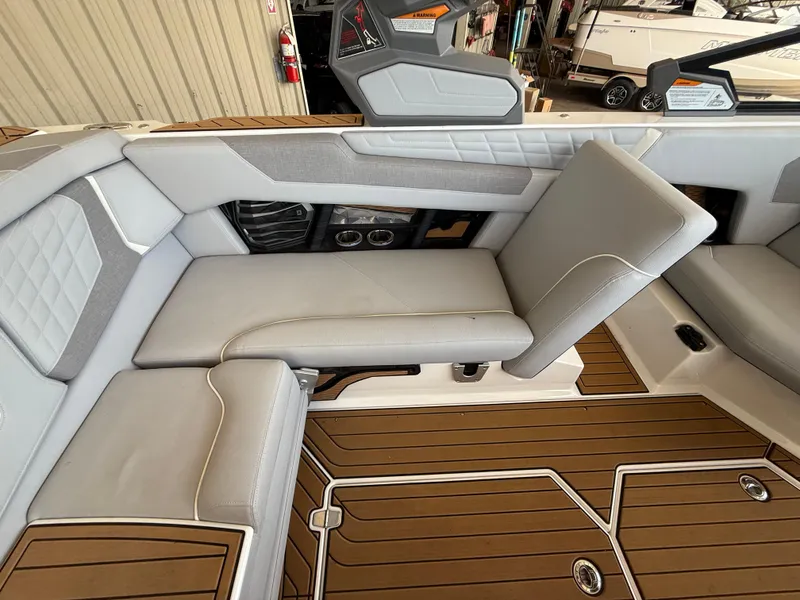 Slide: The Image of 2022 Nautique Super Air G23 interior with gray seating and teak-style flooring. - 15