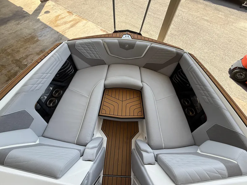 Slide: The Image of 2022 Nautique Super Air G23 boat interior with luxurious gray seating and teak flooring. - 26