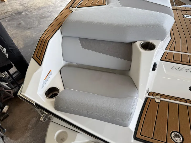 Slide: The Image of 2022 Nautique Super Air G23 boat seating with cup holders and teak accents. - 3