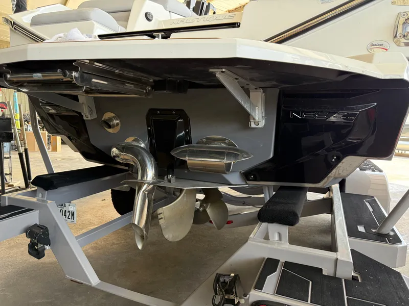 Slide: The Image of 2022 Nautique Super Air G23 boat on trailer, showcasing propeller and hull design. - 30