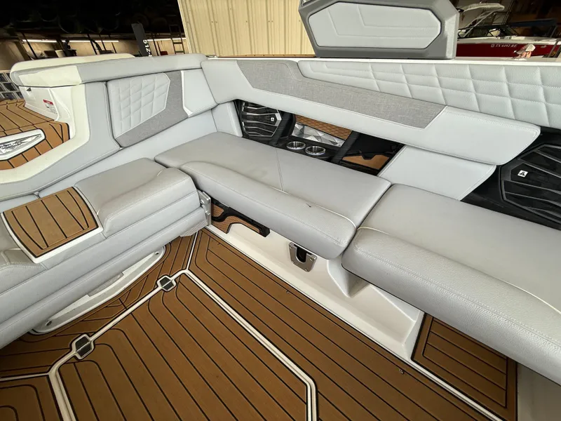 Slide: The Image of 2022 Nautique Super Air G23 interior with gray seating and brown flooring. - 9