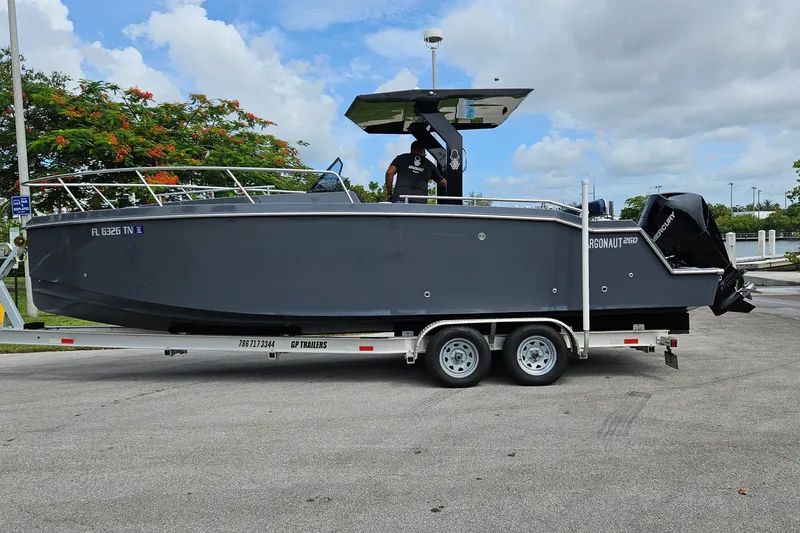 Slide: The Image of 2023 Argonaut 260 boat on trailer, parked outdoors under cloudy sky. - 3