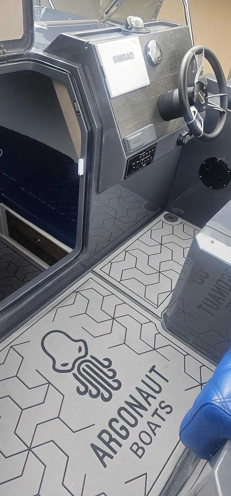 Slide: The Image of Interior of 2023 Argonaut 260 boat with steering wheel and branded flooring. - 5