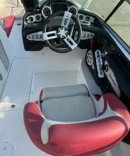 Slide: The Image of 2010 MasterCraft X55 boat cockpit with red and white seating, steering wheel, and control panel. - 3