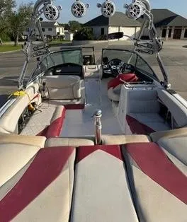 Slide: The Image of 2010 MasterCraft X55 boat interior with red and beige seating, tower speakers, and sleek design. - 4