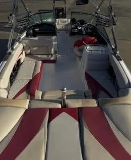 Slide: The Image of 2010 MasterCraft X55 boat interior with red and beige seating, sleek design, and modern dashboard. - 6