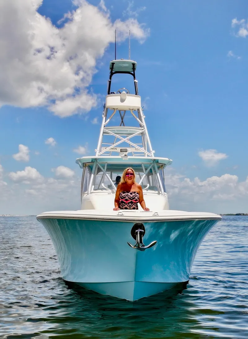 Slide: The Image of 2016 SeaVee 430 Fish Around boat on water, clear sky, person seated at bow. - 16