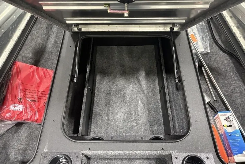 Slide: The Image of Open storage compartment in 2025 Tracker Pro Team™ 190 boat, with red life jacket and accessories. - 10