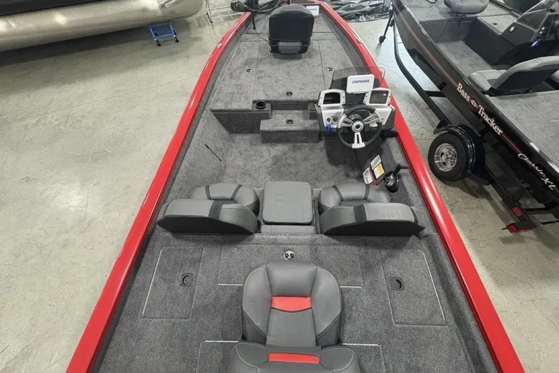 Slide: The Image of 2025 Tracker Pro Team™ 190 boat interior with steering console and seating, featuring a red and gray design. - 30