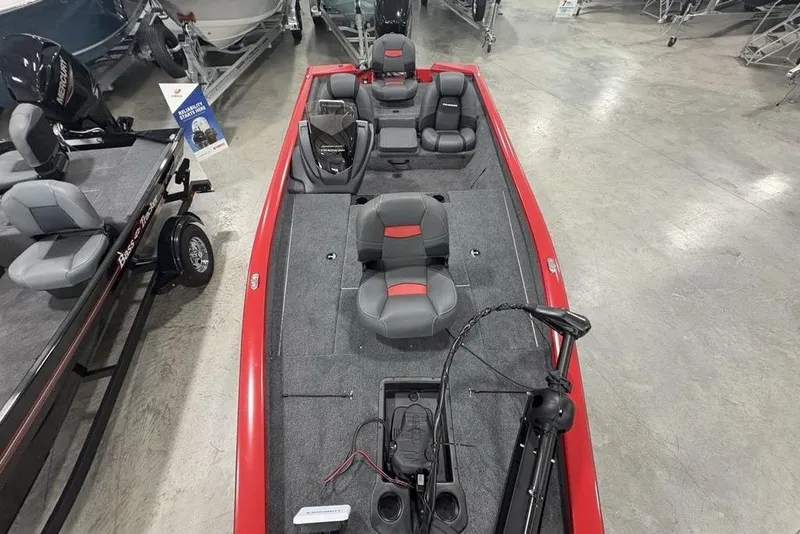 Slide: The Image of 2025 Tracker Pro Team™ 190 boat with red accents and gray seating, displayed indoors. - 31