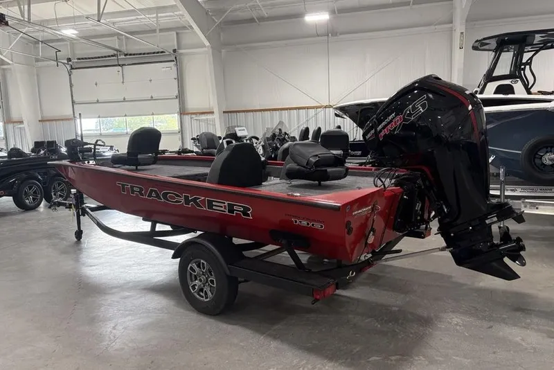 Slide: The Image of 2025 Tracker Pro Team 190 boat in showroom, red exterior, powerful outboard motor. - 4