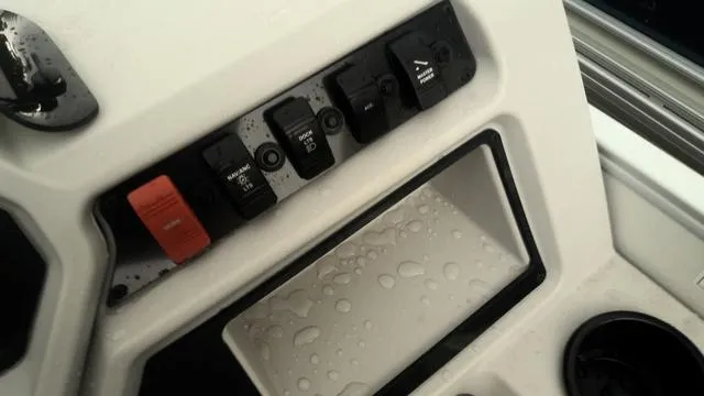 Slide: The Image of Control panel of 2025 Godfrey Pontoons Xperience 2286 SBX, featuring switches and water droplets. - 9