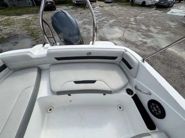 Slide: The Image of 2022 Hurricane SunDeck Sport 185 OB boat interior with seating and motor, parked on gravel. - 16