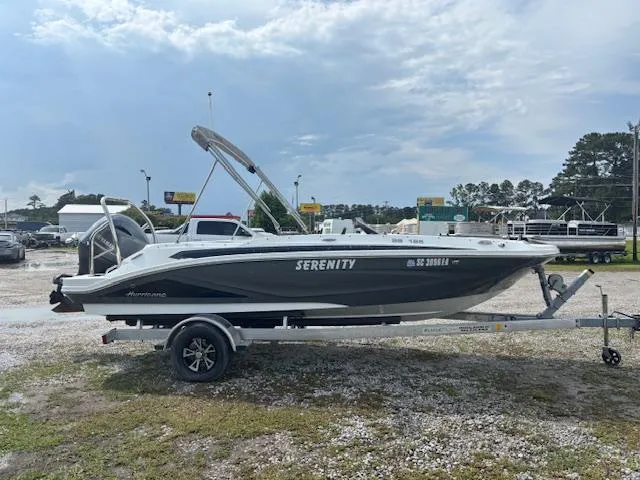 Slide: The Image of 2022 Hurricane SunDeck Sport 185 OB boat on trailer, named "Serenity," in outdoor setting. - 3