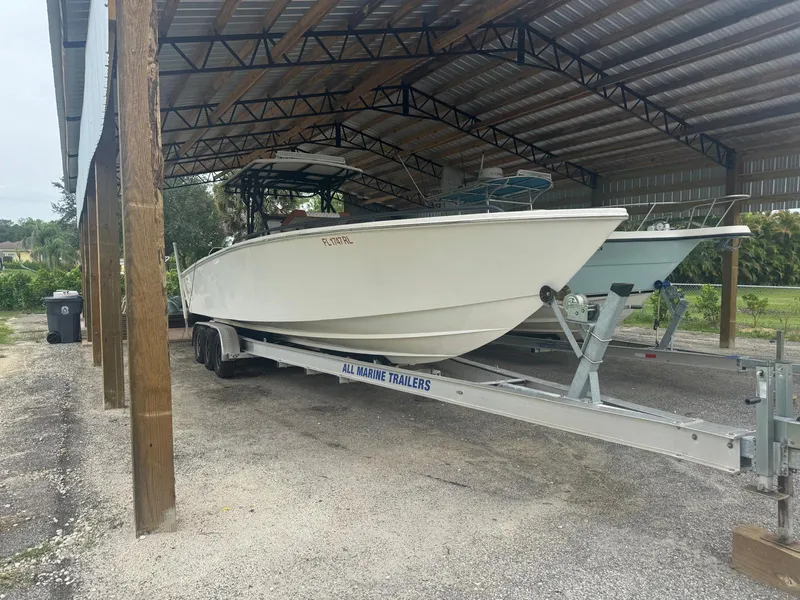Slide: The Image of 2008 Avanti 36 boat on trailer, parked outdoors under a clear blue sky. - 0