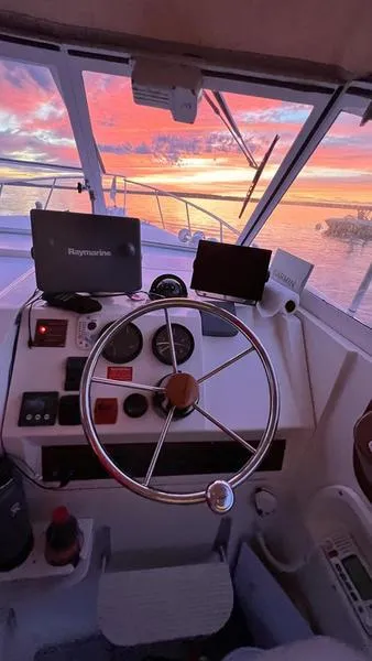 Slide: The Image of 2003 Mainship Pilot 30-II helm with sunset view through windshield. - 10