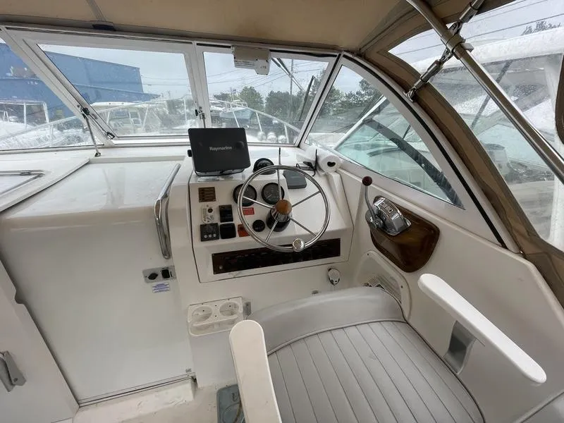 Slide: The Image of 2003 Mainship Pilot 30-II helm with steering wheel, navigation equipment, and seating. - 12