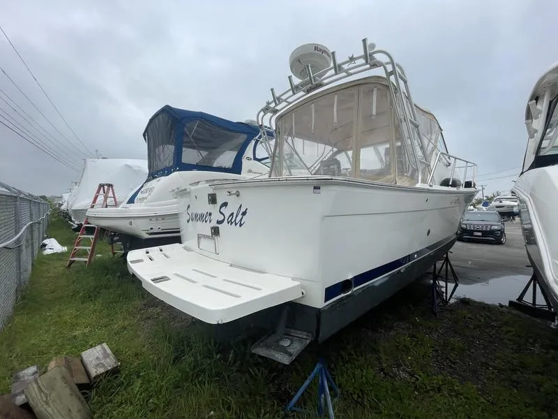 Slide: The Image of 2003 Mainship Pilot 30-II boat on land, surrounded by other boats, overcast sky. - 14