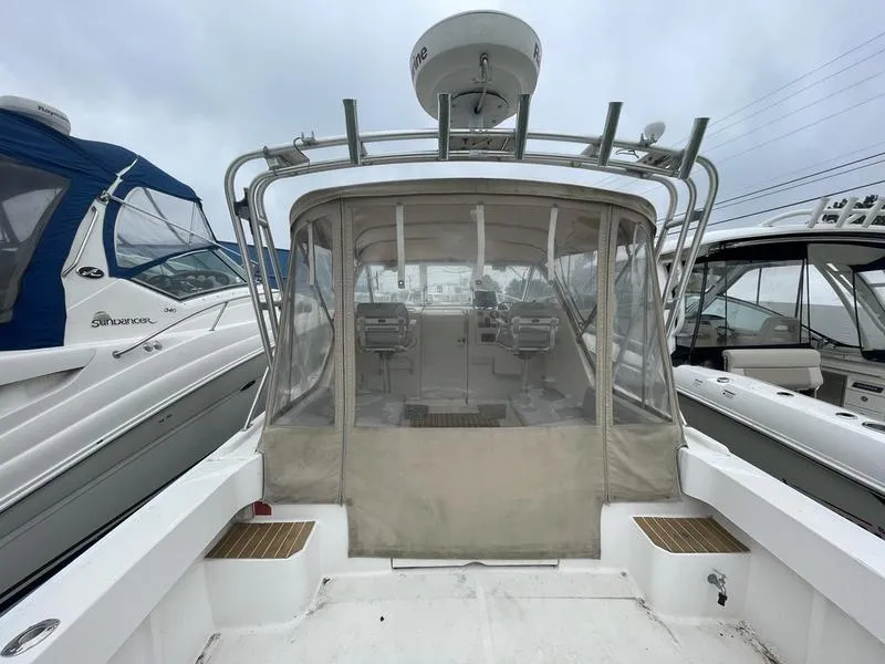 Slide: The Image of 2003 Mainship Pilot 30-II boat with enclosed cockpit, docked alongside other vessels. - 18