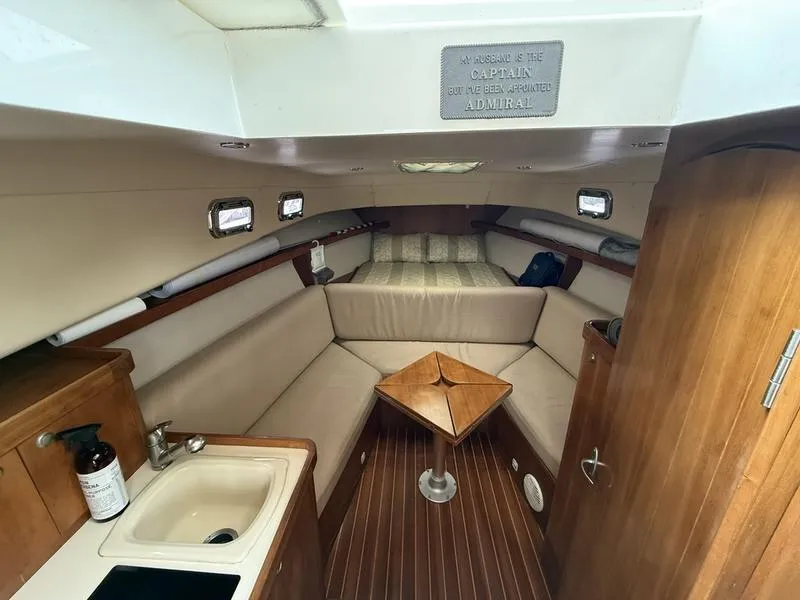 Slide: The Image of 2003 Mainship Pilot 30-II cabin interior with seating, table, and sink. - 7