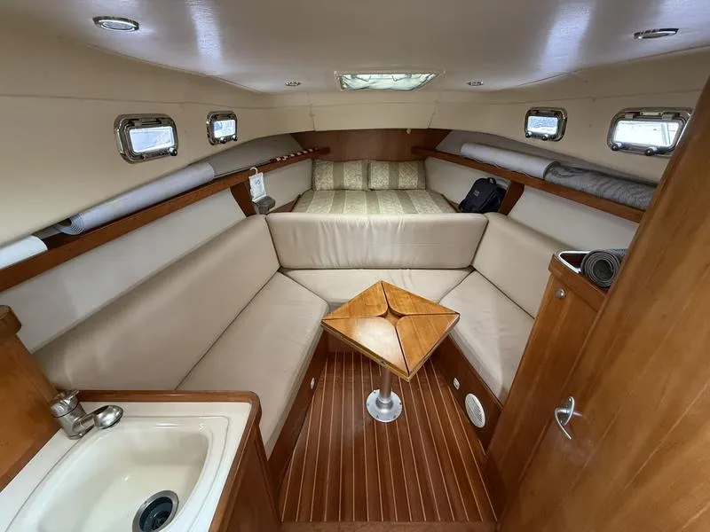 Slide: The Image of 2003 Mainship Pilot 30-II cabin interior with seating, table, and portholes. - 8