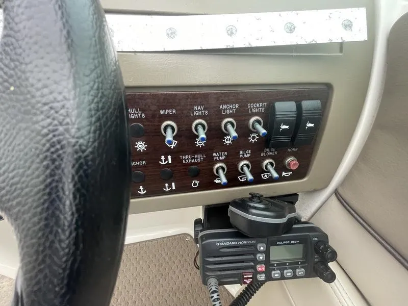 Slide: The Image of Control panel of a 2012 Sea Ray 260 Sundeck boat with various switches and a radio. - 2