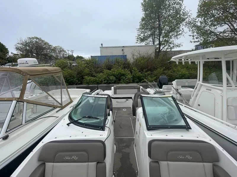 Slide: The Image of 2012 Sea Ray 260 Sundeck boat with dual windshields, docked alongside other boats. - 6
