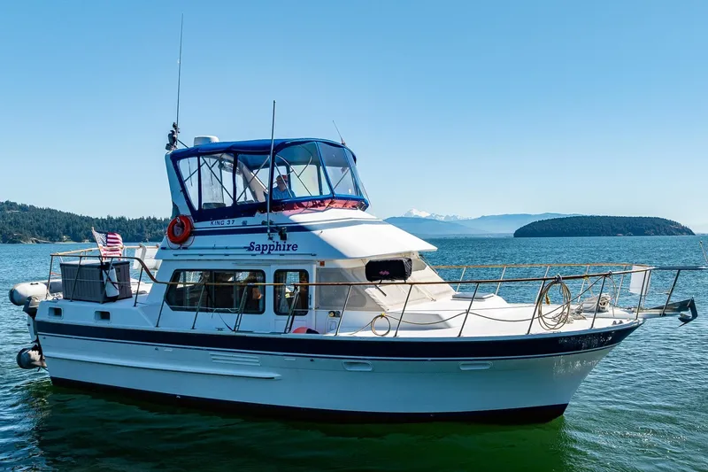 Slide: The Image of 1986 Kha Shing 37' yacht "Sapphire" cruising on a sunny day with scenic island backdrop. - 1