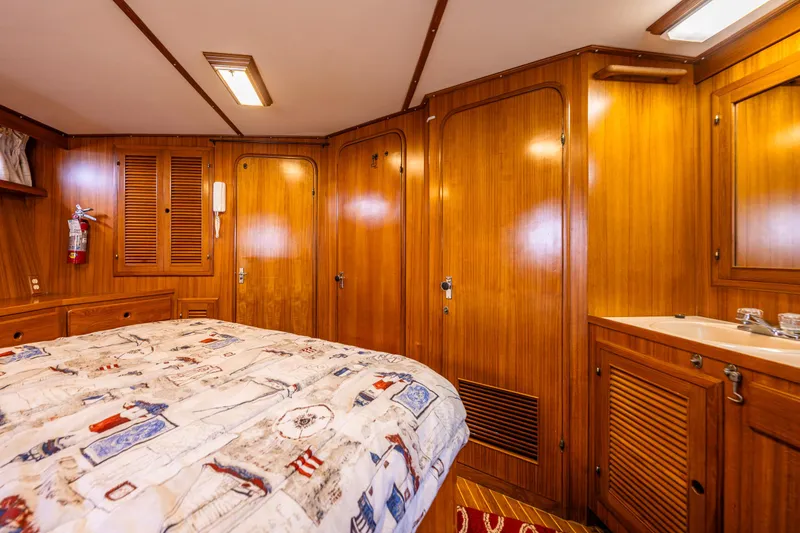 Slide: The Image of 1986 Kha Shing 37' yacht cabin with wooden interior and nautical-themed bedding. - 14