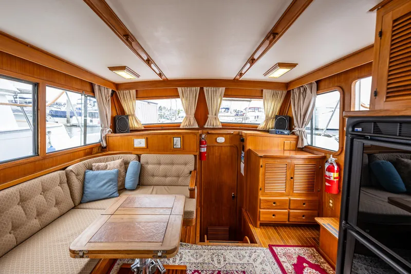 Slide: The Image of Interior of a 1986 Kha Shing 37' yacht with wood paneling and cozy seating area. - 16