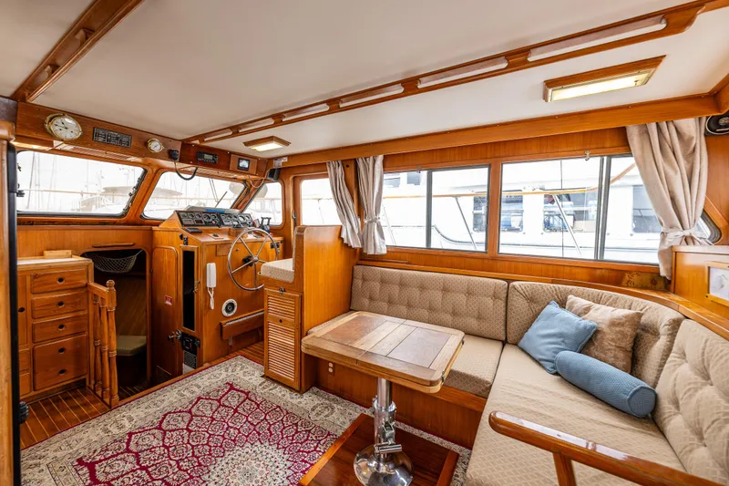 Slide: The Image of 1986 Kha Shing 37' yacht interior with wood finish, cozy seating, and nautical decor. - 20